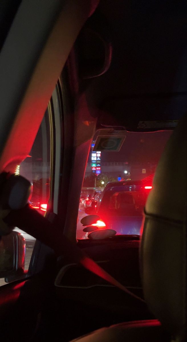 the interior of a car at night with red lights