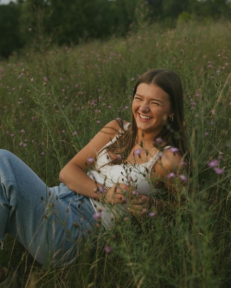 a woman is sitting in the tall grass