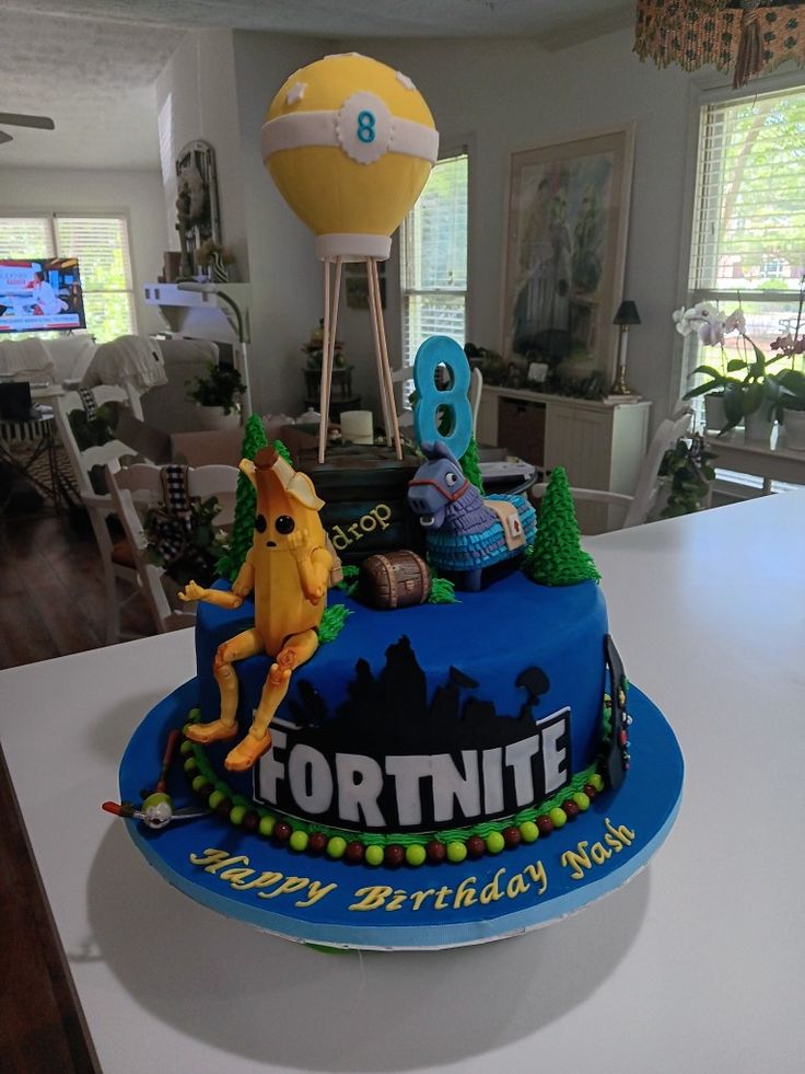 a birthday cake is decorated to look like a fortnite character on top of it