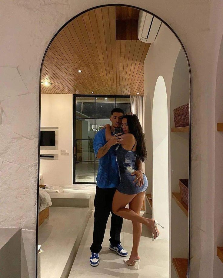 a man and woman are taking a selfie in the mirror at their apartment's entrance