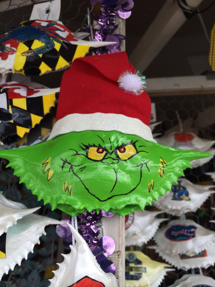 a green grin face mask on a stick in front of cupcakes for sale