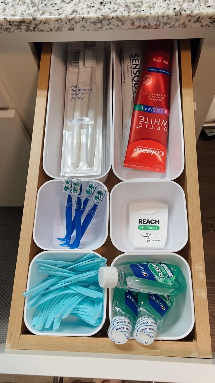 an organized drawer with toothpaste, mouthwashes and other hygiene products in it