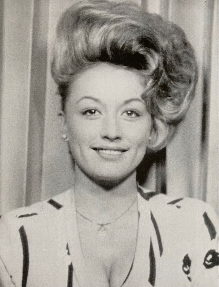 an old black and white photo of a woman smiling