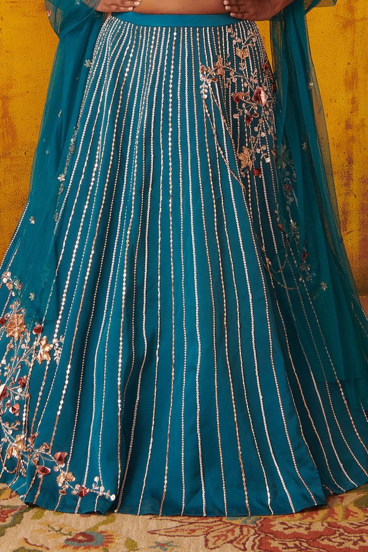 Teal blue embroidered kalidar lehenga. Paired with a bustier blouse and sheer dupatta.
Components:3
Pattern:Hand embroidered
Type of Work:Sequins, Cutdana work, Bead work
Neckline:V neck
Sleeve Length:Sleeveless
Fabric:Silk, Tabby silk
Color:Blue
Other Details:
Strappy embroidered blouse
Occasion:Wedding, Sangeet - Aza Fashions Bustier Blouse, Sheer Dupatta, Cutdana Work, Pink Peacock, Fabric Silk, Blue Silk, Bridal Lehenga, Embroidered Blouse, Set For Women