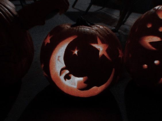 two carved pumpkins sitting on top of a table