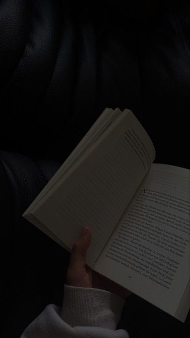 someone is reading a book in the dark