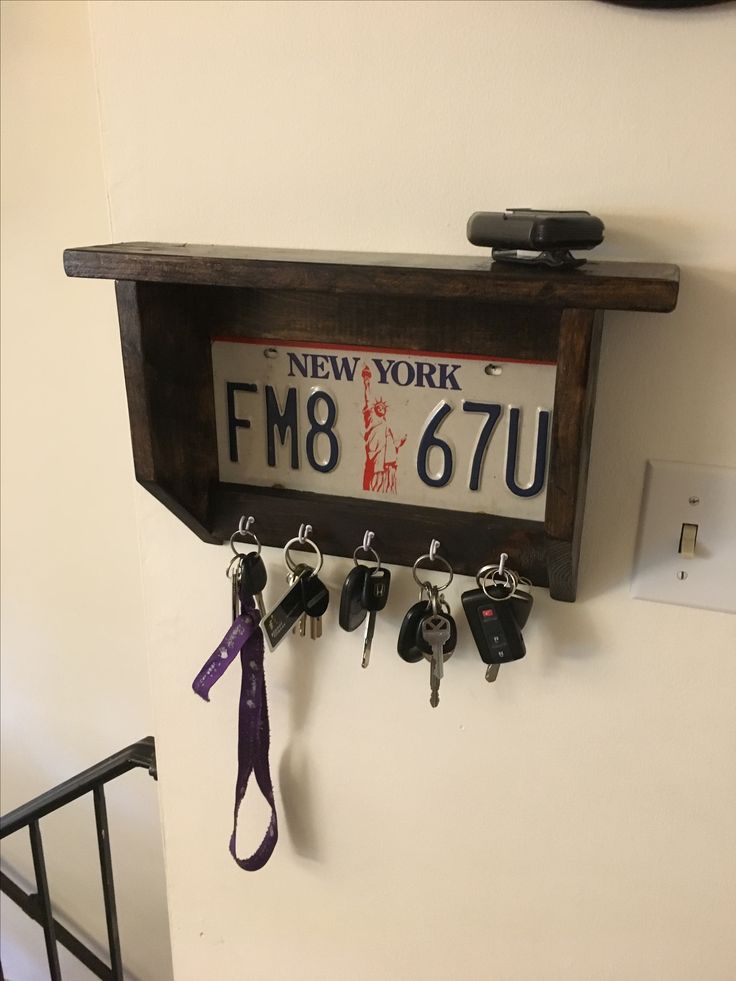 a wooden shelf with key hooks and keys hanging from it