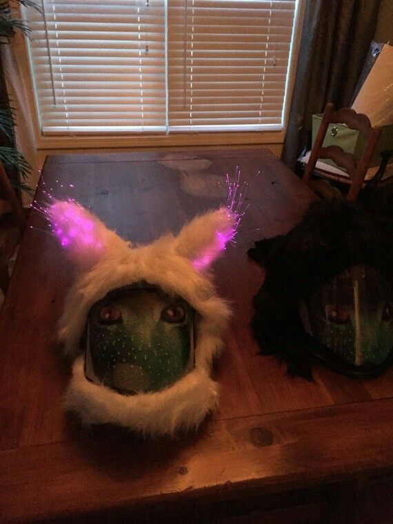 a cat's head with glowing ears on top of a wooden table next to a window