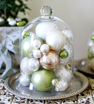 a glass cloche with ornaments underneath it