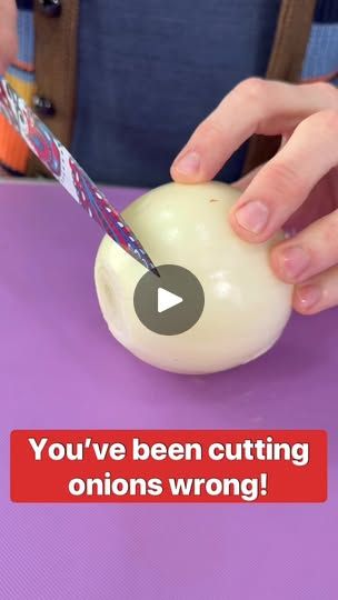 someone cutting an onion with a knife on a purple tablecloth that says, you've been cutting onions wrong