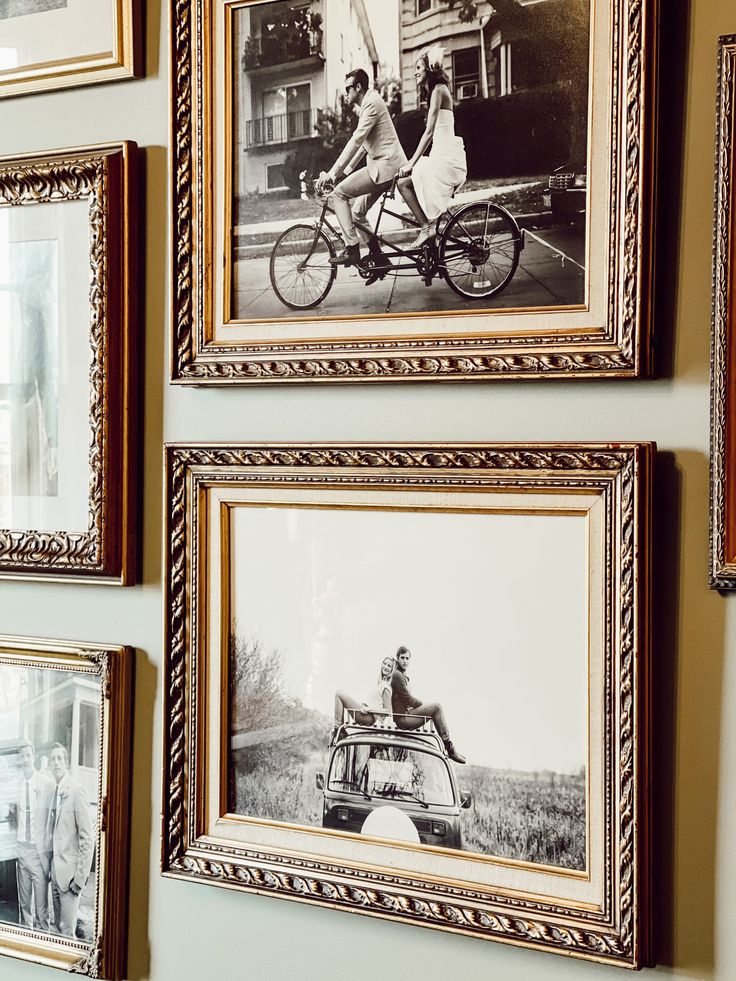 several framed pictures hang on the wall above a car and two people in a wagon