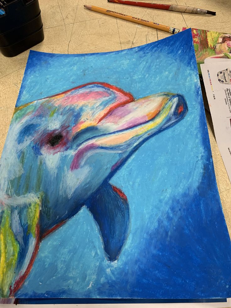 a painting of a dolphin is shown on the floor next to some paintbrushes