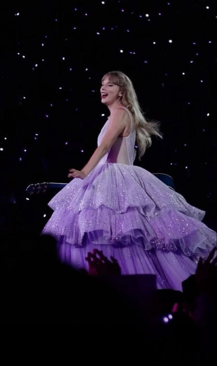 a woman in a purple dress on stage