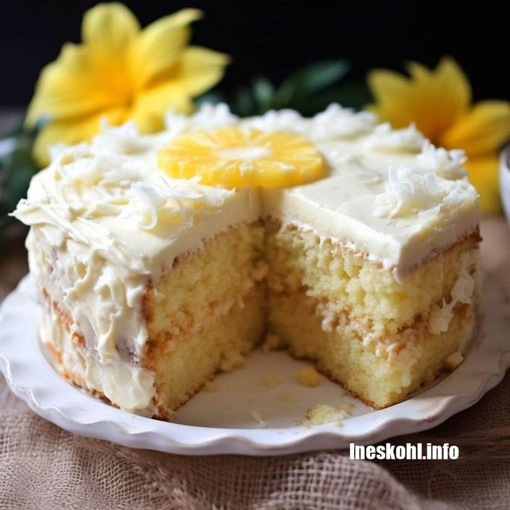 there is a cake with white frosting and lemons on it, cut in half