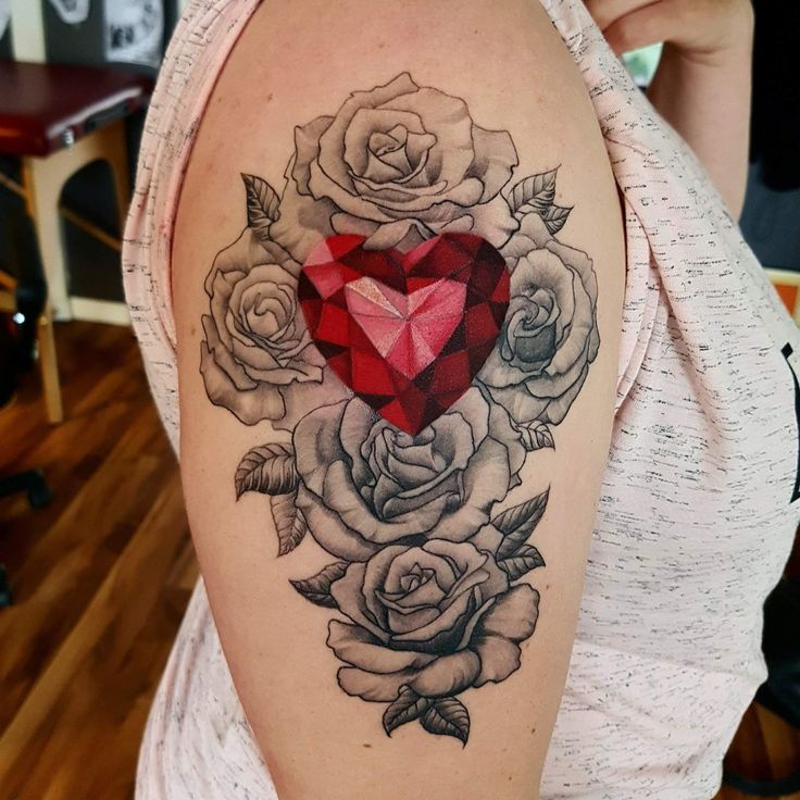 a woman's shoulder with roses and a heart on it