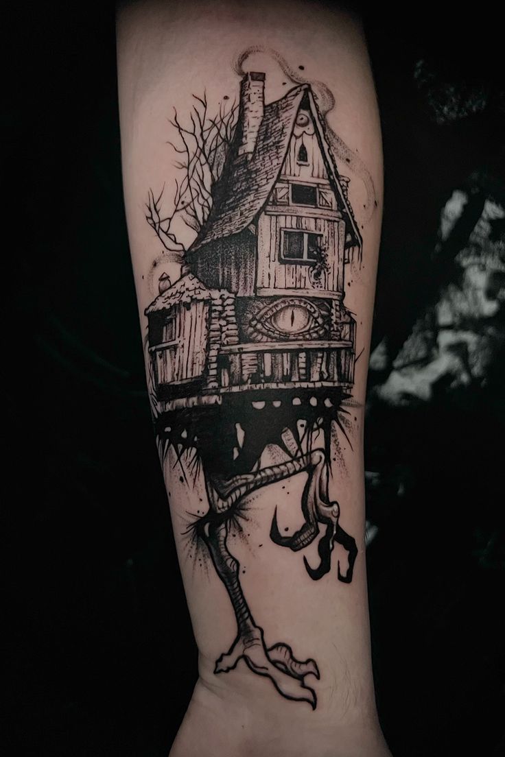 a black and white tattoo with a house on it's arm in the shape of a tree