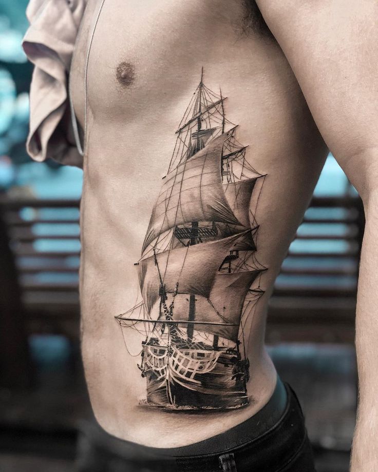 a man's chest with a ship tattoo on it