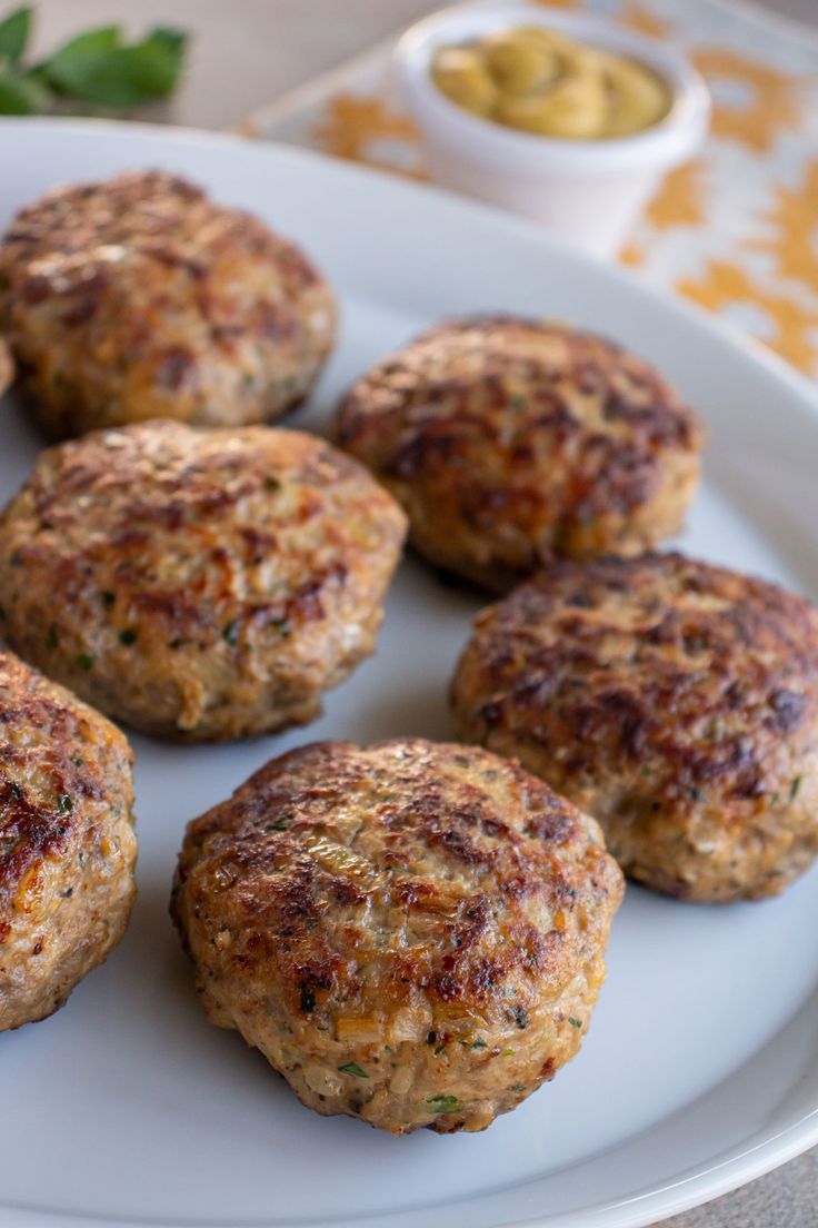 some meat patties are on a white plate