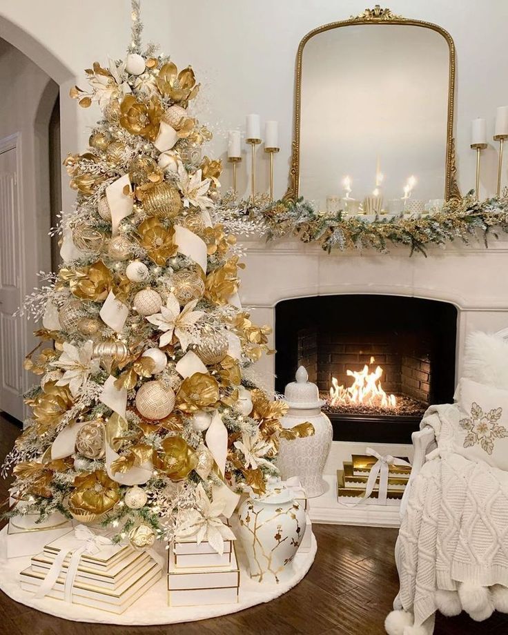 a white christmas tree with gold and silver ornaments in front of a fireplace decorated for the holidays