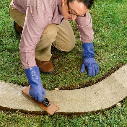 a man in blue gloves is working on a piece of wood that has been cut into the ground