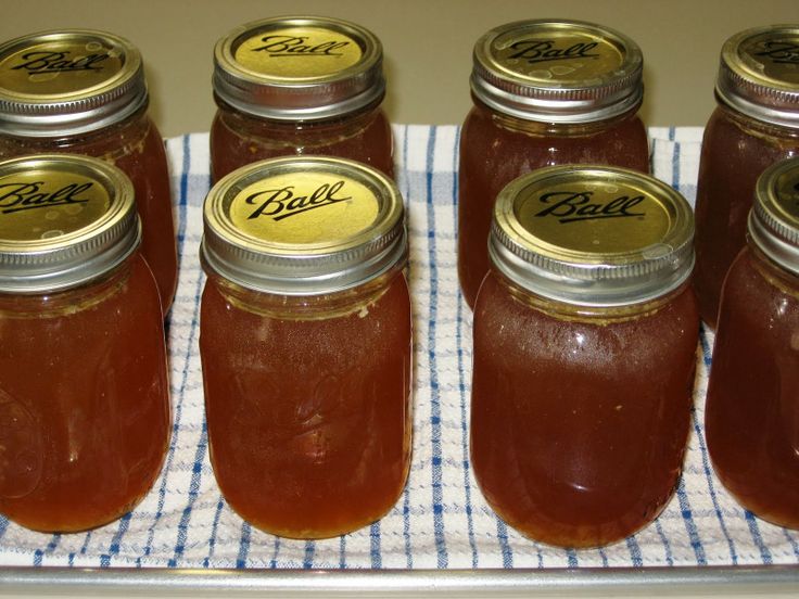 six jars filled with jam sitting on top of a blue and white checkered cloth