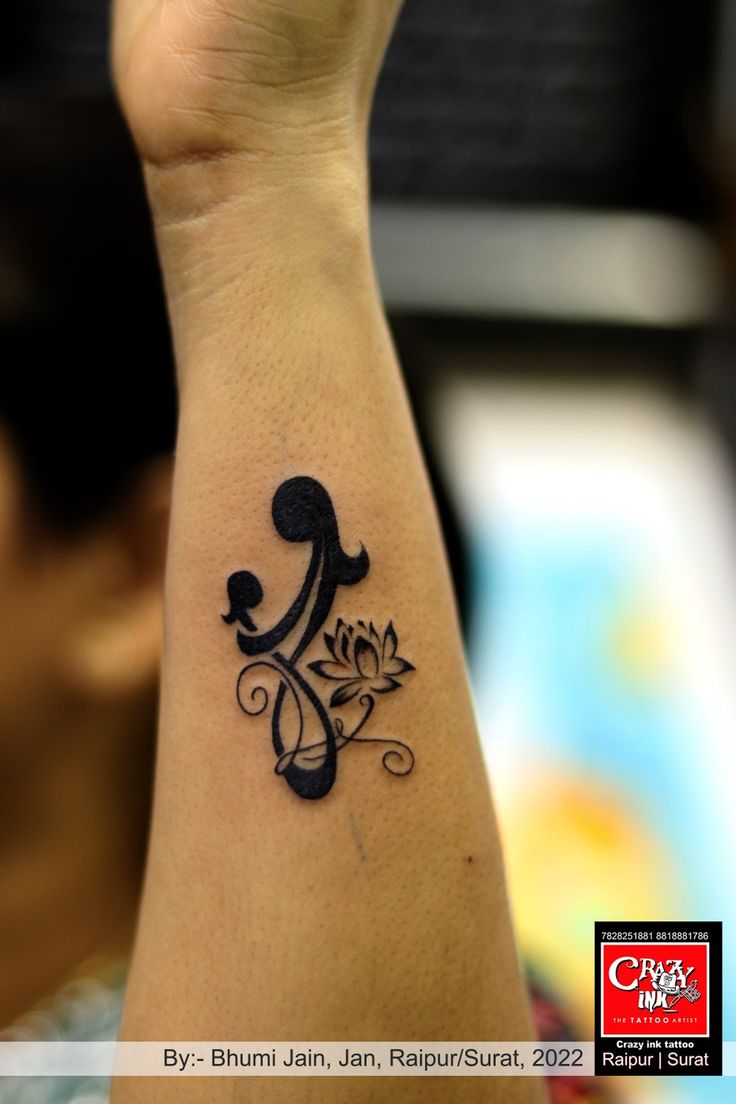 a woman's arm with a tattoo on it that has a musical note in the middle