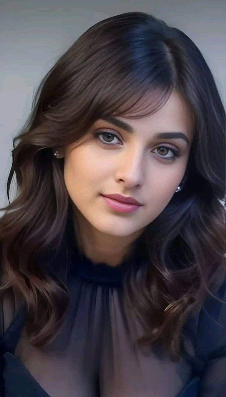 a close up of a person wearing a black dress and posing for the camera with long hair