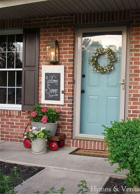 a blue front door with two buckets filled with flowers