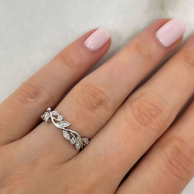 a woman's hand with pink manicured nails and a ring on her finger