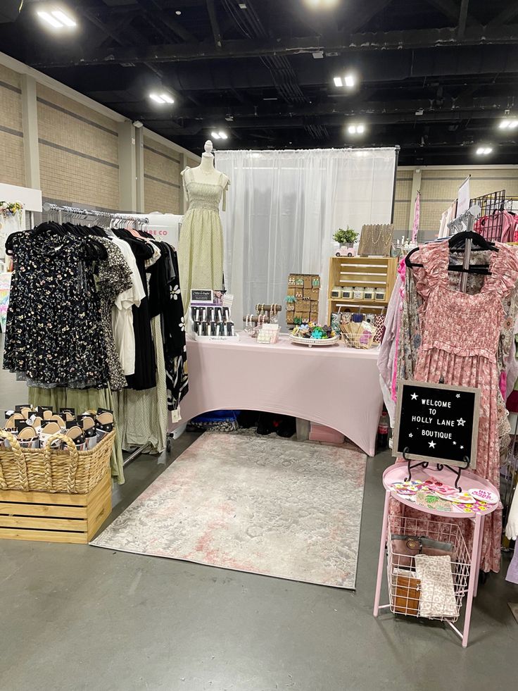 a clothing store with clothes on display and other items in the foreground, including a pink table