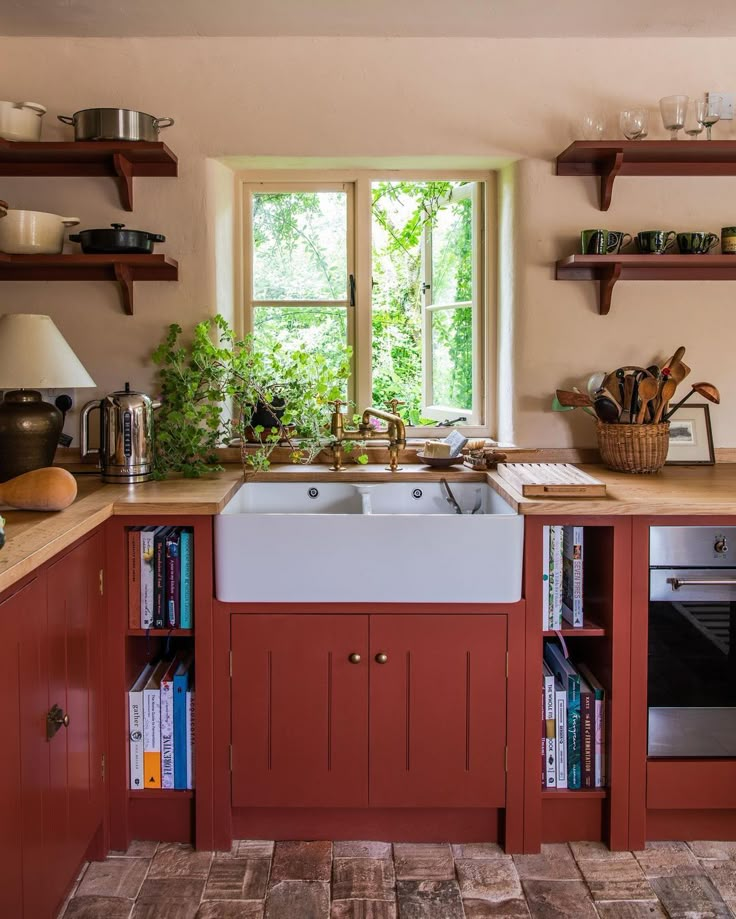 a kitchen with red cabinets and white sink