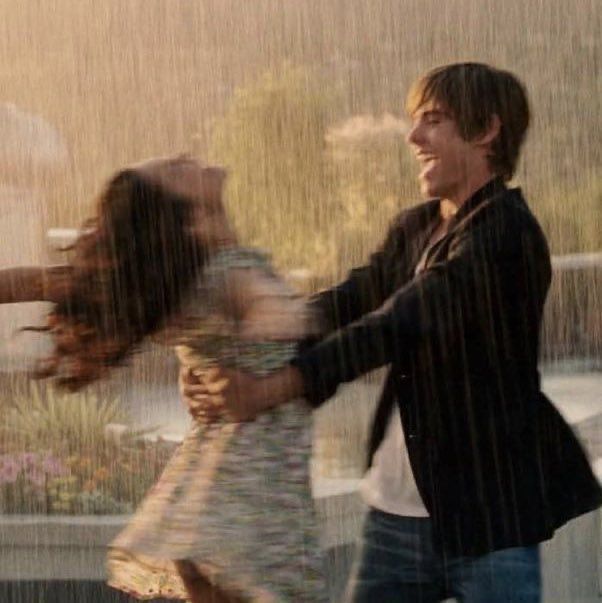 a man and woman dancing in the rain