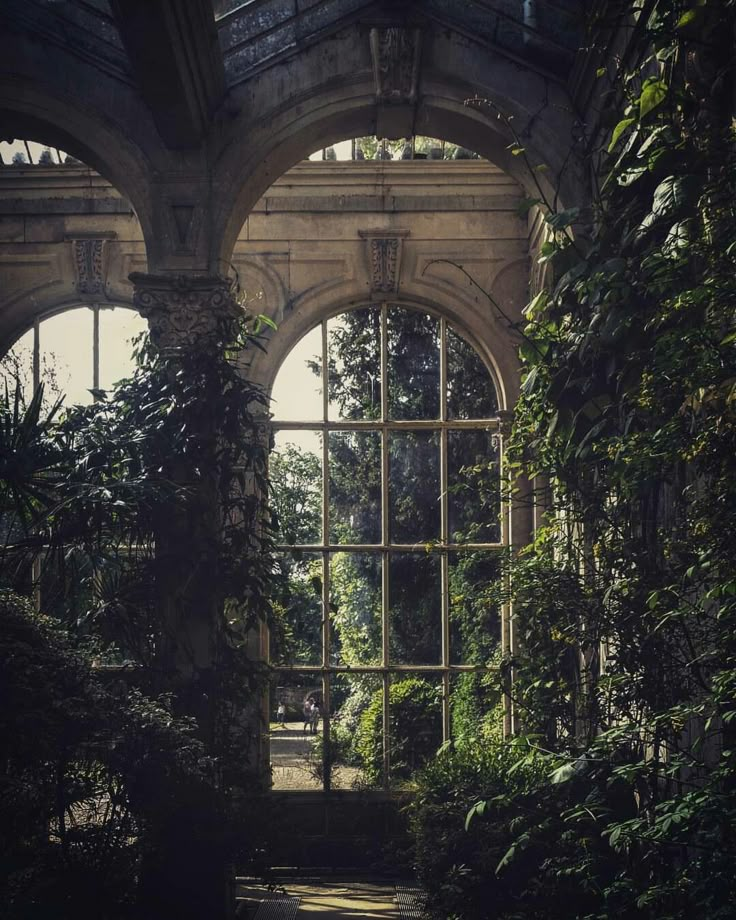 an old building with lots of windows and plants