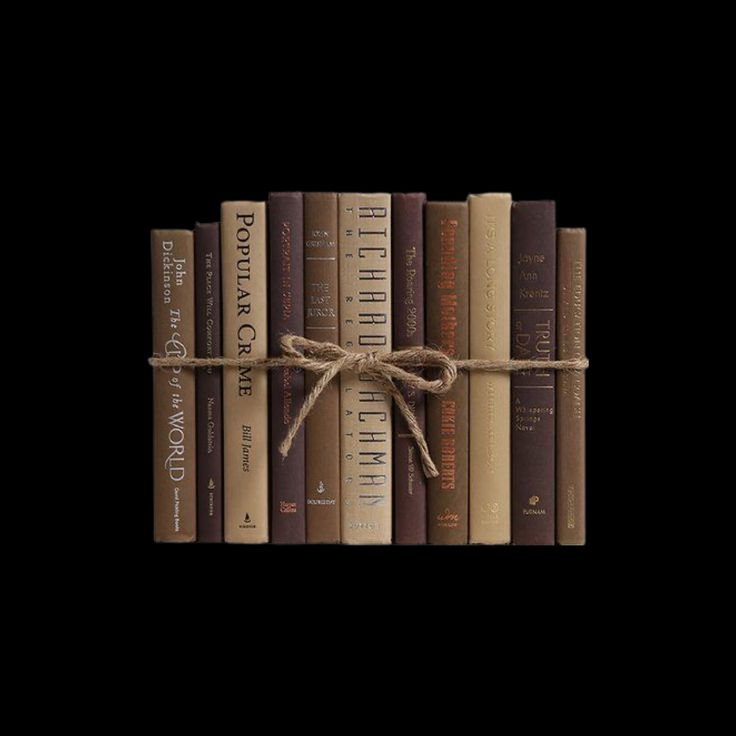 a row of books tied up with a brown rope on top of them in front of a black background