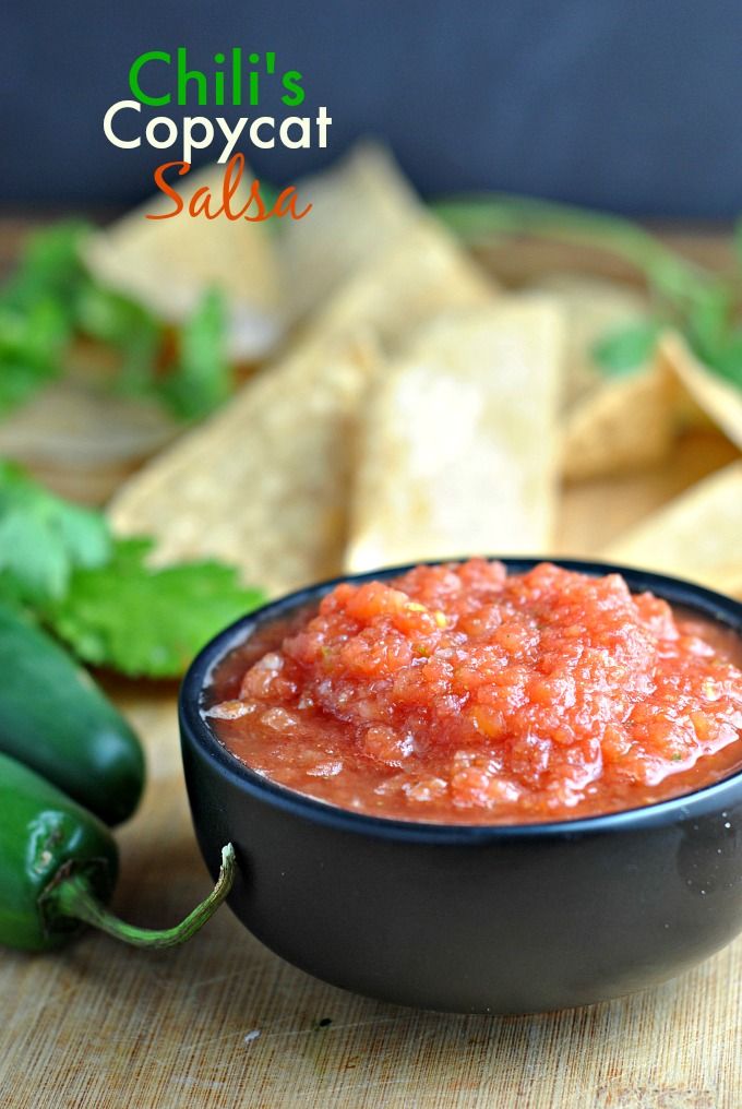 a black bowl filled with salsa next to tortilla chips