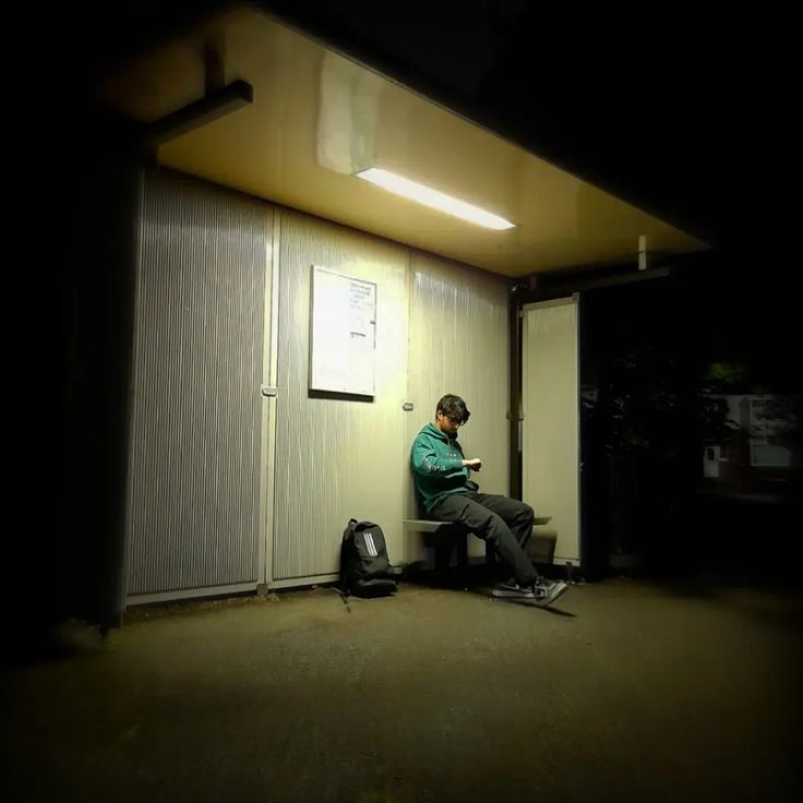 a man sitting on top of a bench next to a door in an office building