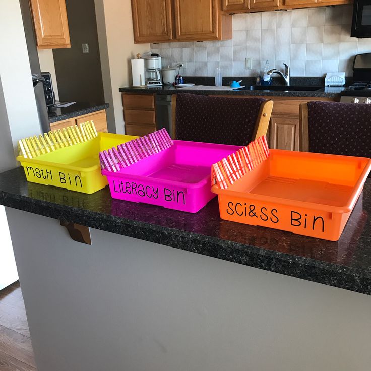 three plastic trays with words on them sitting on a counter in a home kitchen