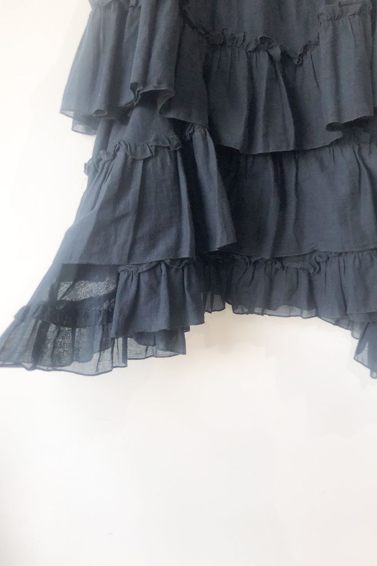 Hache Black Tiered Ruffle Skirt. Great condition. Solid black tiered and ruffle knee length skirt with slight handkerchief hem. Has elastic at waist band for easy pull on. 100% Cotton. Marked as size 42. Made in italy. Approx. Measurements: Underarm to Underarm: 16 1/2" laid flat Length: 23" at center and 29" at sides Black Tiered Gathered Skirt, Ruffled Flared Skirt Dress, Chic Tiered Skirt With Layered Hem, Chic Tiered Voluminous Skirt, Chic Layered Tiered Skirt, Chic Tiered Dress With Relaxed Skirt, Chic Voluminous Tiered Skirt, Black Flowy Tiered Skirt, Black Tiered Skirt With Ruffles