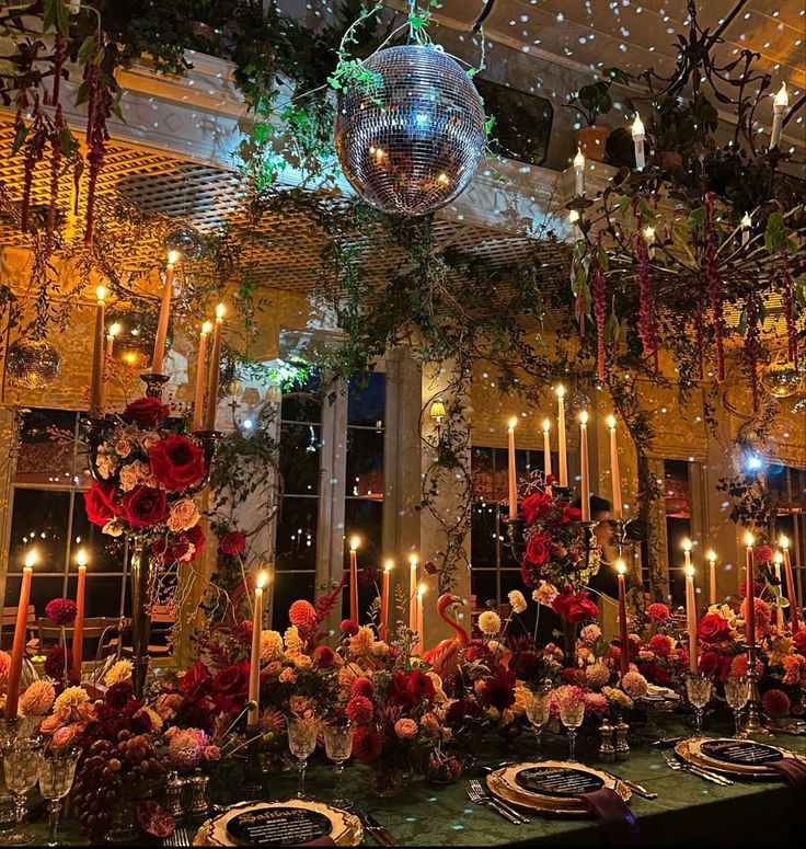 a table is set with candles, flowers and plates for an elegant dinner or party