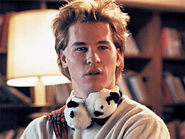 a young man with a stuffed panda bear in his neck is looking at the camera