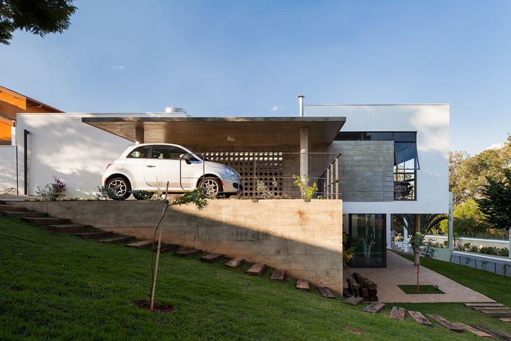 a white car parked in front of a modern house