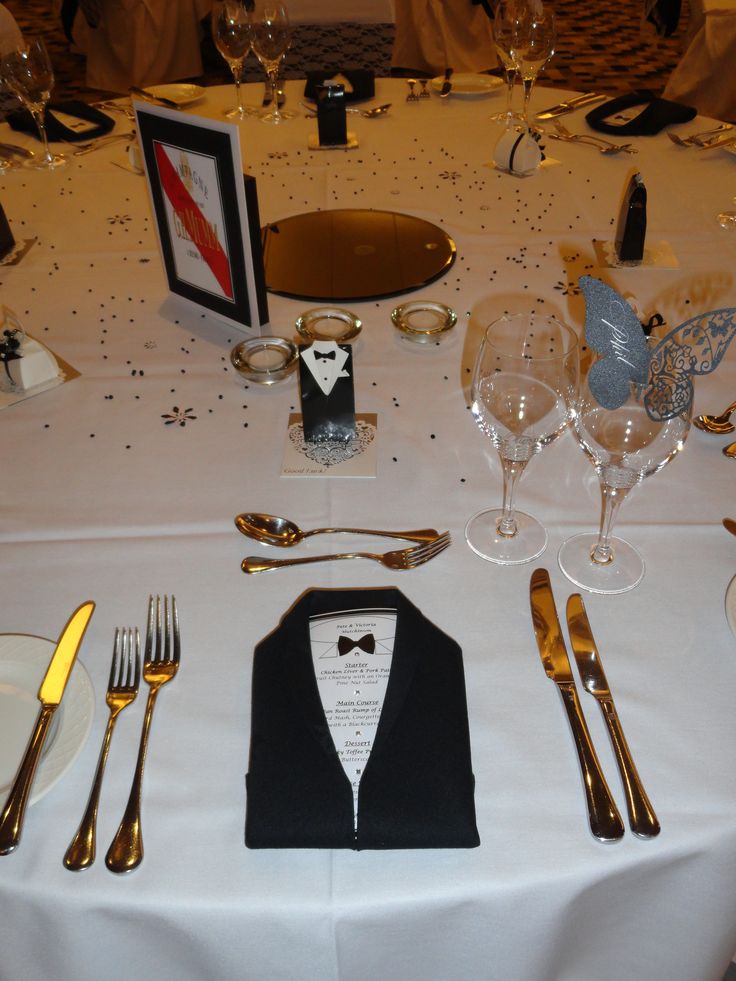 the table is set up with silverware and place settings for formal dinnereons