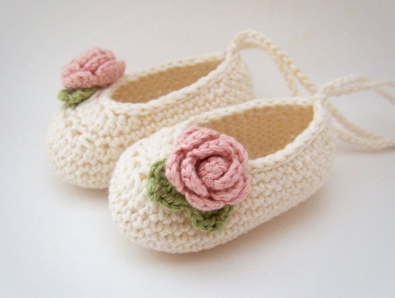 a pair of crocheted baby shoes with flowers on them