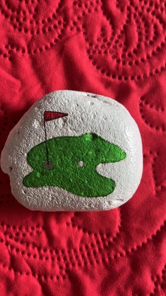 a green and white rock with a flag on it sitting on a red tablecloth