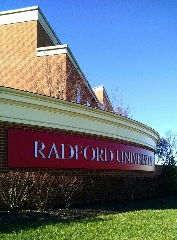 the sign for radford university in front of a brick building with trees and grass