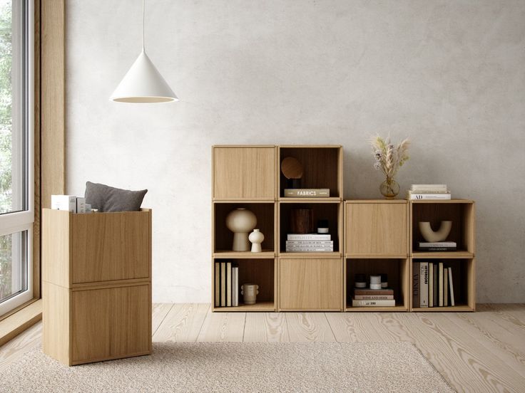 a wooden shelf with books and vases on it next to a wall mounted lamp