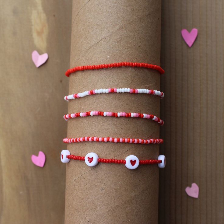 the bracelets have hearts on them and beads are red, white, and pink