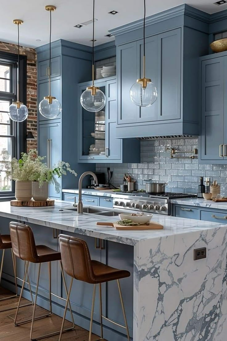 a kitchen with blue cabinets and marble counter tops in the center, along with bar stools