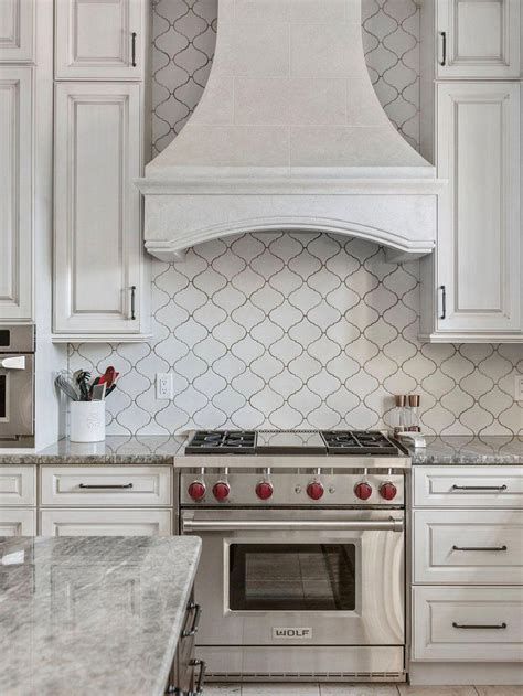 a stove top oven sitting inside of a kitchen next to white cabinets and counter tops