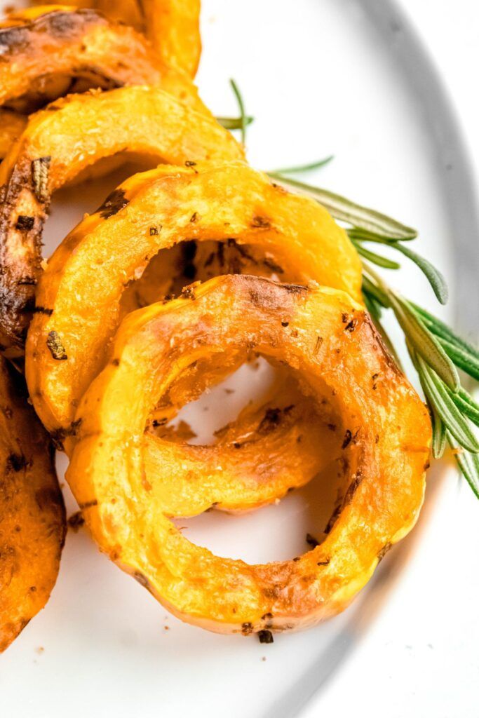 some fried food on a white plate with rosemary